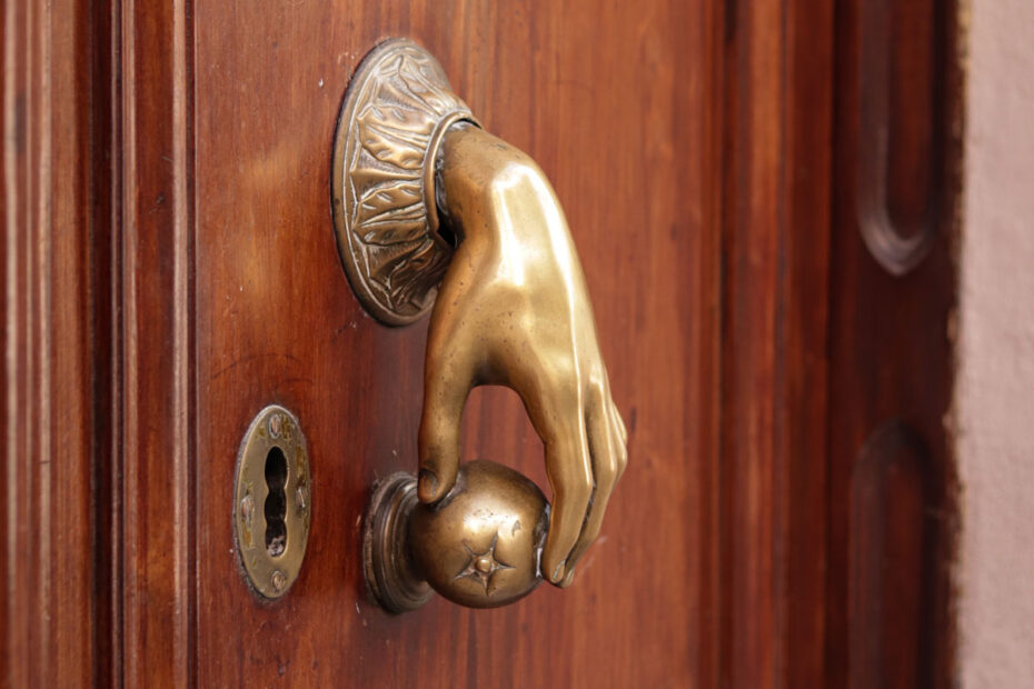 Sometimes the unexpected happens in business and it's an opening for creativity. (Image of hand-shaped door knocker opening door knob)