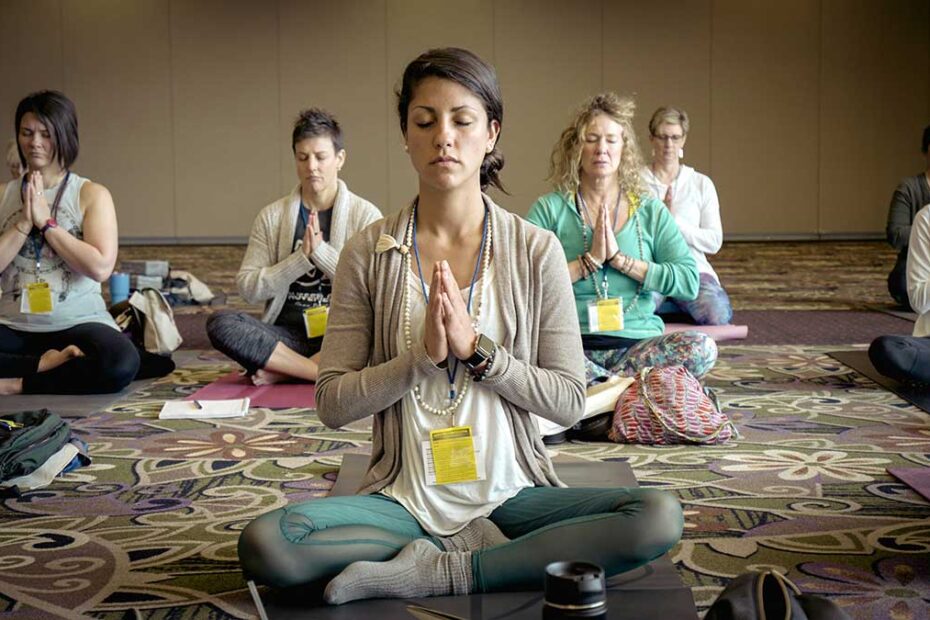 People enjoying meditation and yoga to create a more positive workplace and healthier employees