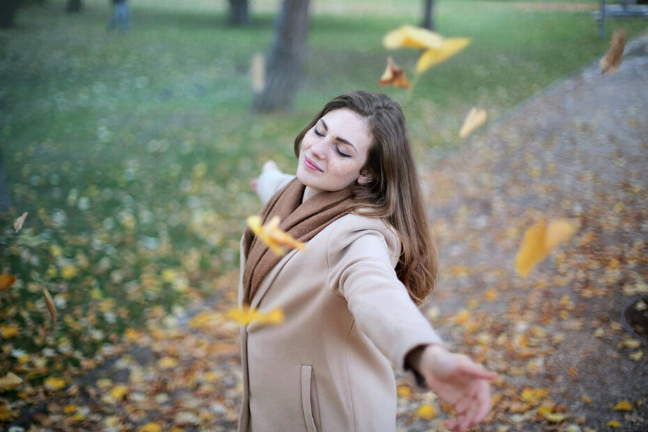A woman dancing in the falling leaves feels delight, which leads to gratitude and fulfillment